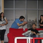 Theatre performance of the shy actor. Two men, two women, one red couch. One man yells at the other man
