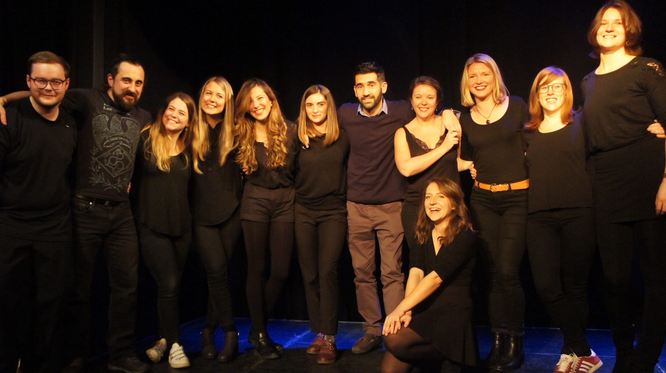 Act Attack's improv and physical show. A group of people on stage wearing black clothes. Group photo after the show